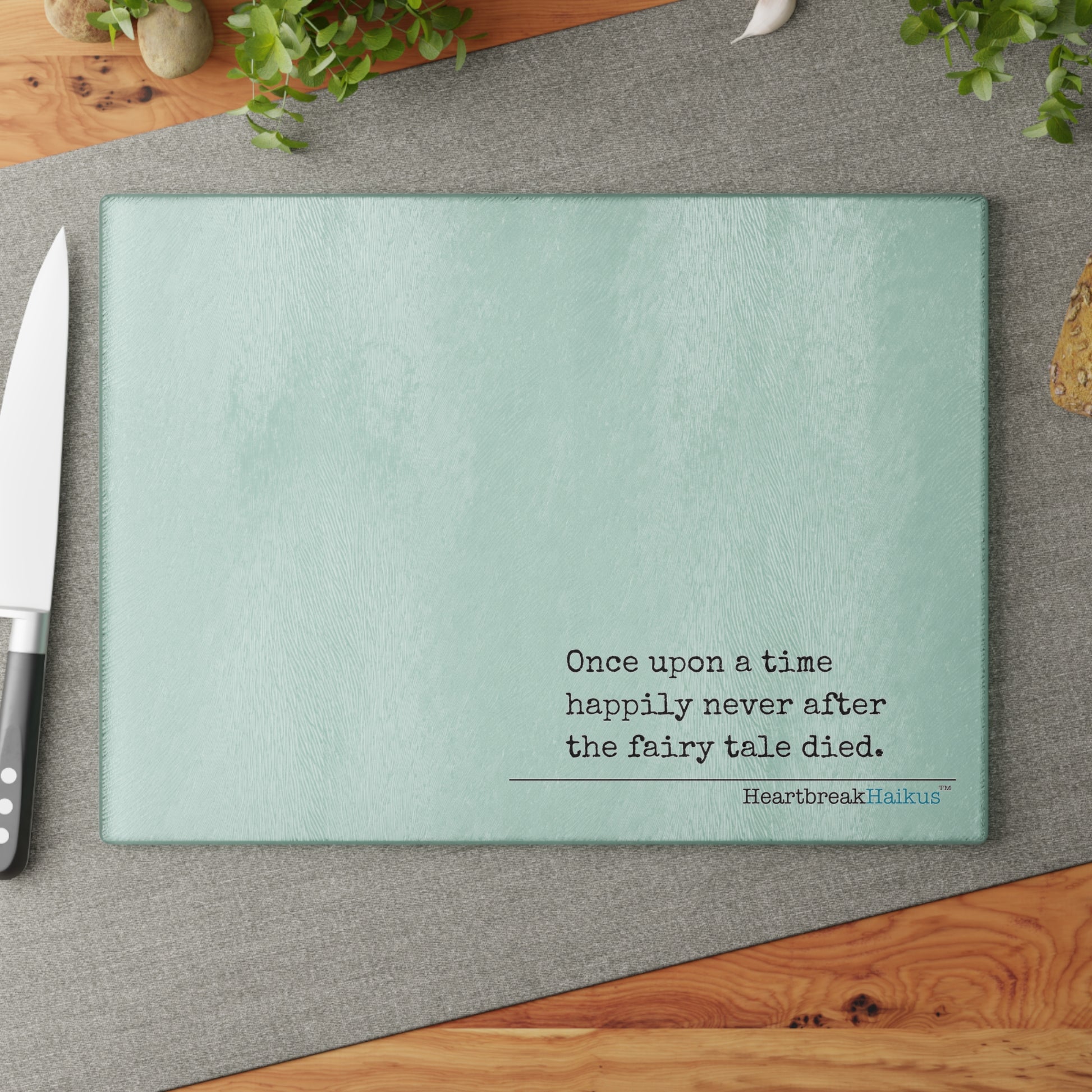 This cutting board features an original Heartbreak Haiku, perfect for adding a touch of creativity to your kitchen. The durable tempered glass material makes it a versatile preparation surface, while the vibrant colors and unique decoration process ensure