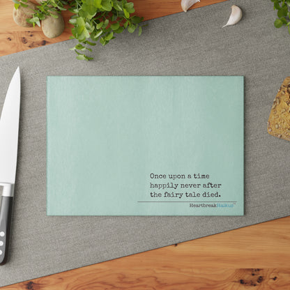 This cutting board features an original Heartbreak Haiku, perfect for adding a touch of creativity to your kitchen. The durable tempered glass material makes it a versatile preparation surface, while the vibrant colors and unique decoration process ensure